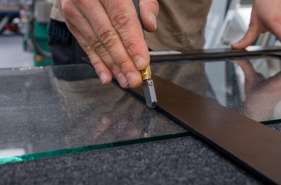 Glazier cutting glass to size for a glazing project in Stirling and Central Scotland